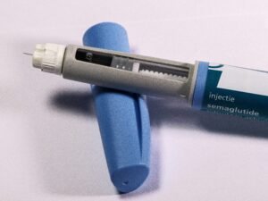 Ozempic effetti collaterali: penna di semaglutide accanto a un bicchiere d'acqua per gestire la nausea