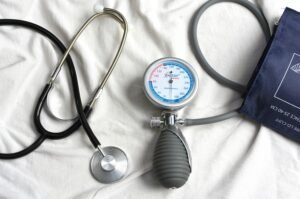 Pressione bassa: misuratore con valori bassi e bicchiere d'acqua su un tavolo d'estate
